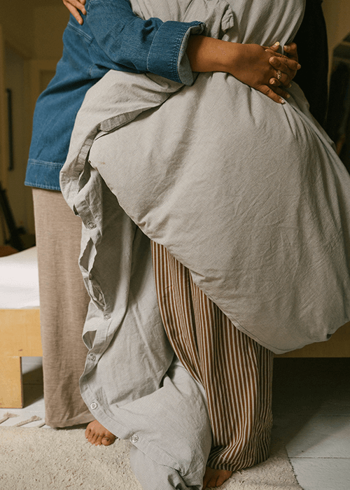 Dos personas se abrazan antes de dormir con un edredón
